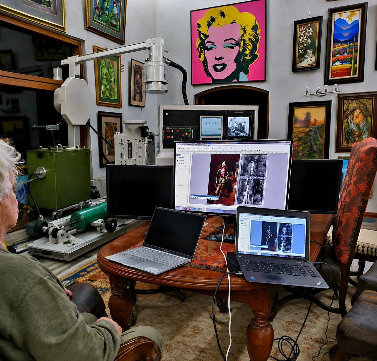 Llewellyn Kruger examining a painting with technical imaging equipment at Kunssinnig Gallery